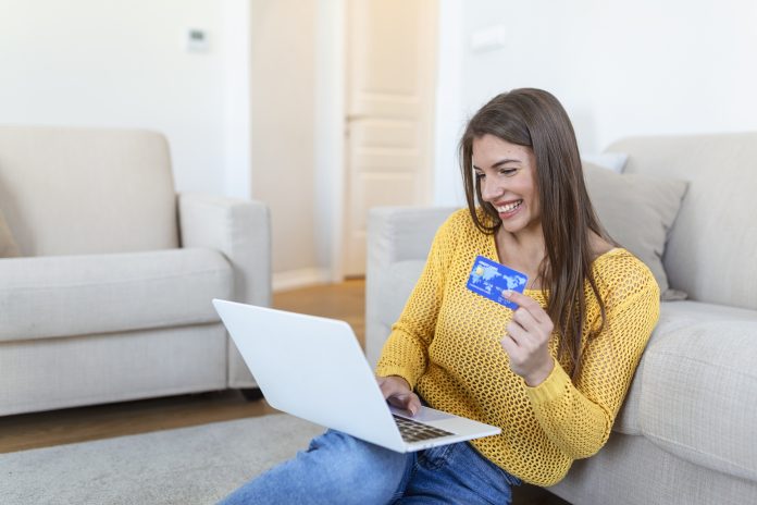 Picture showing pretty woman shopping online with credit card. woman holding credit card and using laptop. Online shopping concept